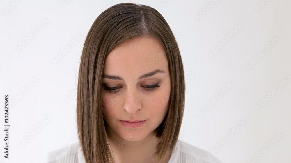 Serious woman looking down lifts her head and looks at camera Serious woman looking down lifts her head and looks at camera