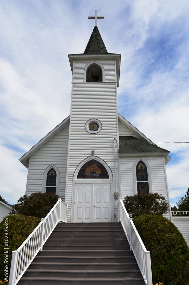 Traditional style architecture Christian church and steeple against a summer sky Traditional style architecture Christian church and steeple against a summer sky