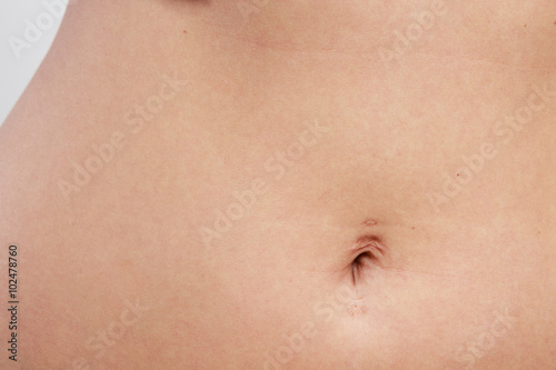 woman belly with piercing scar in the navel