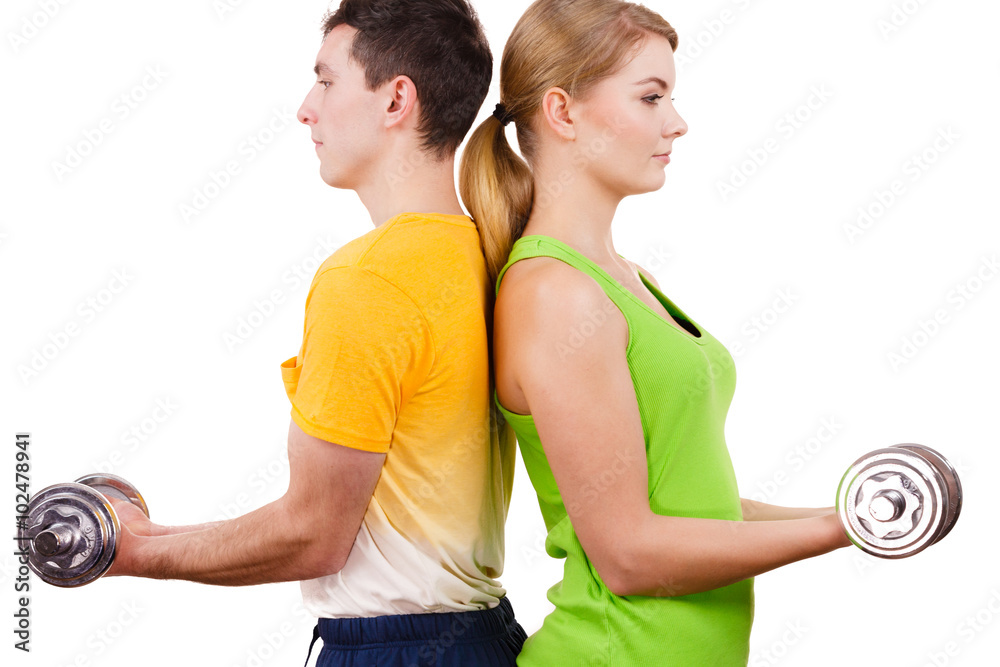 Couple exercising with dumbbells lifting weights Couple exercising with dumbbells lifting weights