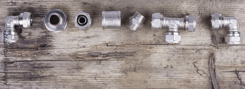 tools fittings plumbing on a woody background