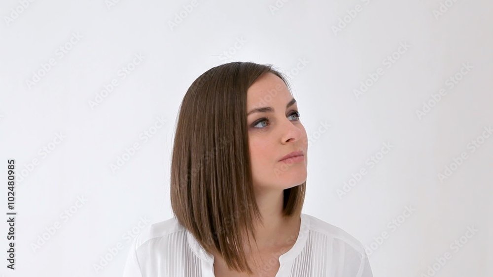 Woman moves her head looking around while thinking and remembering something, trying to contain laugh Woman moves her head looking around while thinking and remembering something, trying to contain laugh
