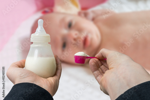 Hands holds bottle with milk formula prepaired for feeding baby. photo