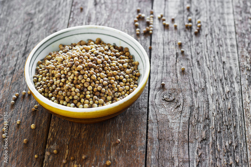 coriander seeds on the wooden background