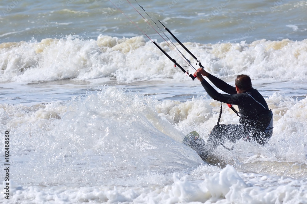 Naklejka premium Kitesurfer on sea waves.