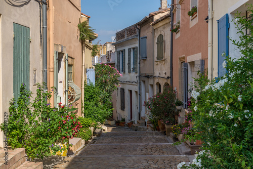 Bended street with coloured houses and flowers in Arles, France on a sunny day in summer
