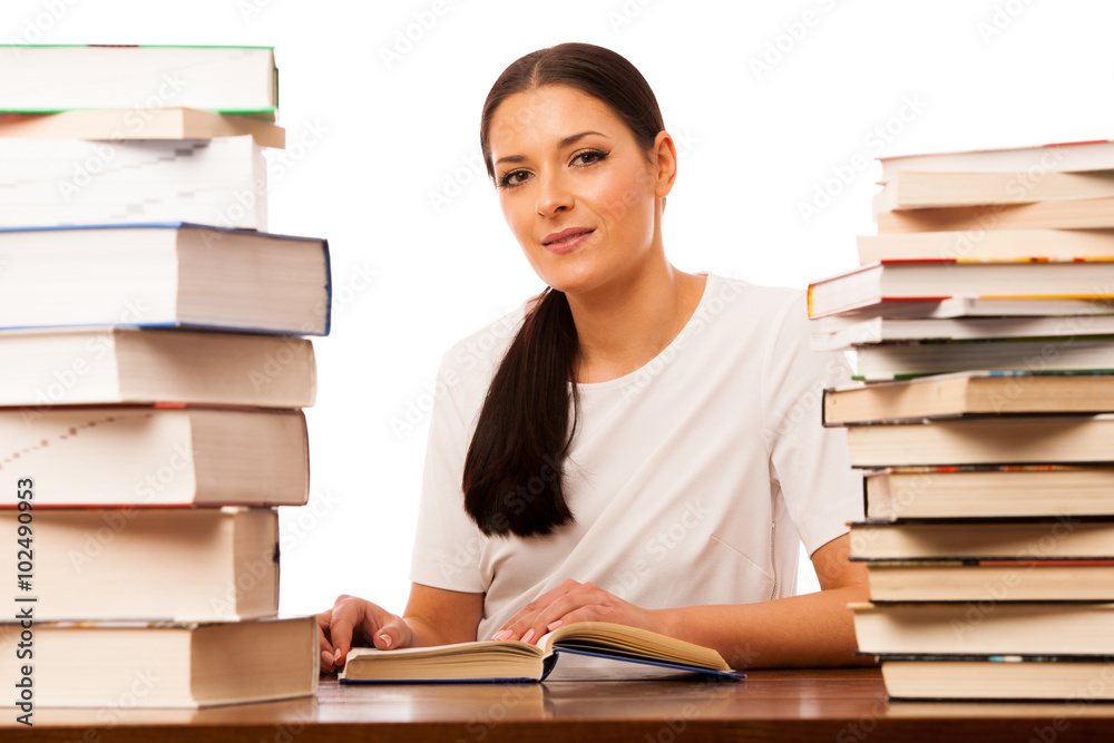 Woman reading behind the table between two pile of books. Woman reading behind the table between two pile of books.