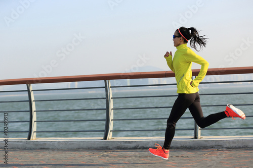 Fototapeta Naklejka Na Ścianę i Meble -  young fitness woman runner running on seaside