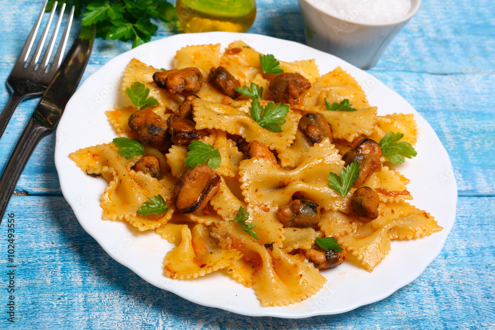 pasta with mussels and parsley on a wooden background