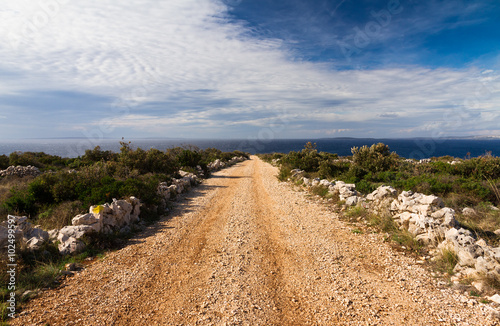 Country road down a hill leading towards the sea