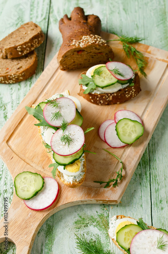 Sandwiches with egg, radish, cucumber and arugula