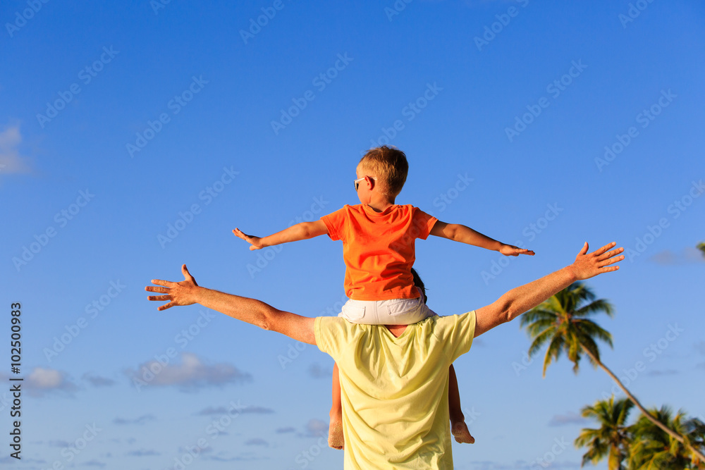 happy father and little son on shoulders play at sky happy father and little son on shoulders play at sky