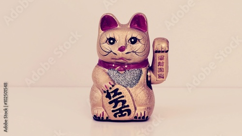 cinemagraph of a chinese lucky cat moving its left paw up and down