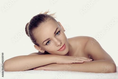 Girl lies on a towel in a spa. She looks very pleased and relaxe