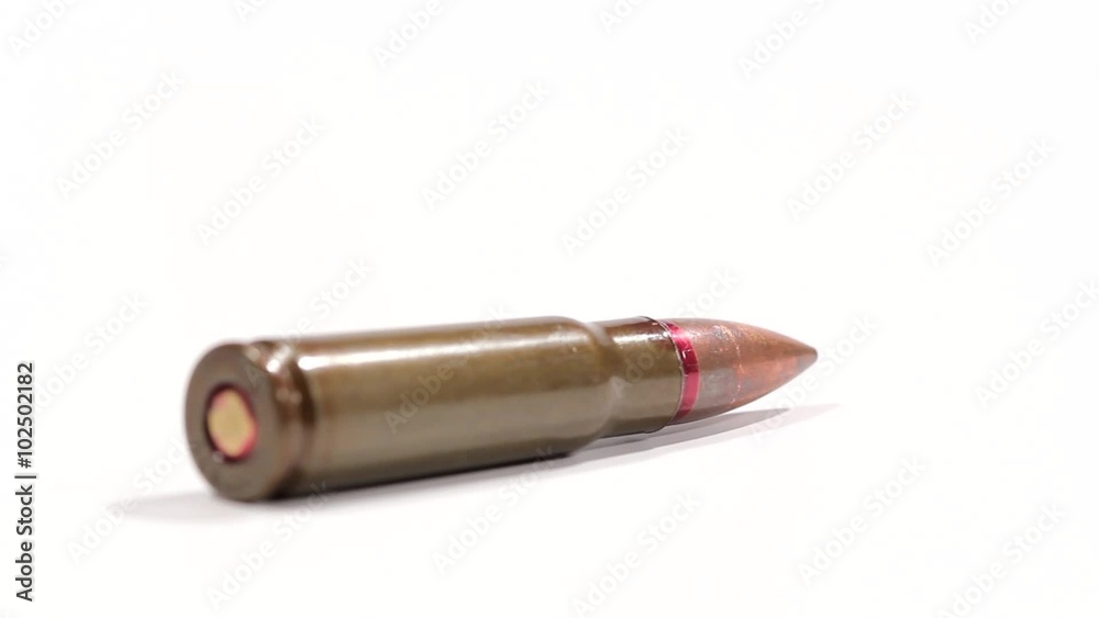 AK 47 ammunition. Defocus on a laying single bullet's bottom. From the back to the front. White background. AK 47 ammunition. Defocus on a laying single bullet's bottom. From the back to the front. White background.