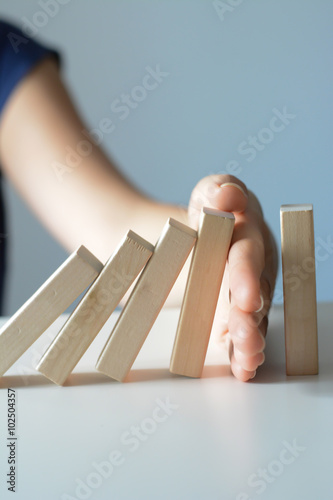 Stopping the domino effect concept with a business solution and intervention photo