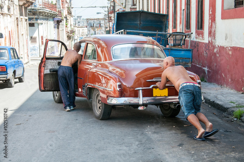 two men pushing the car in the street
