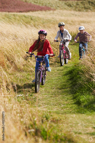 Group Of Children Riding Bikes Through Countryside