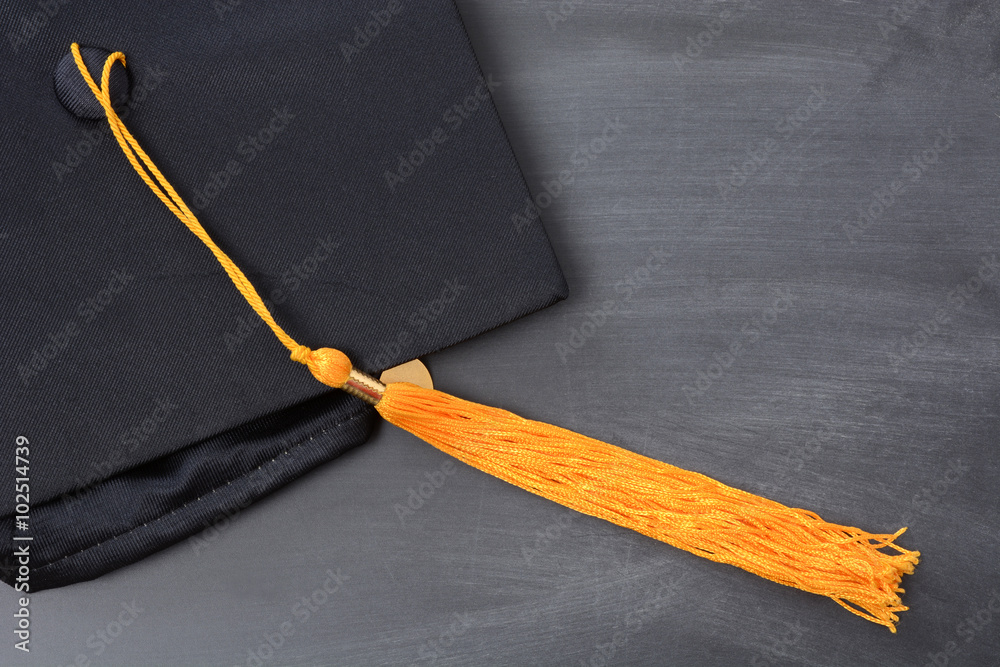 graduation cap with gold tassel on blackboard background Stock Photo