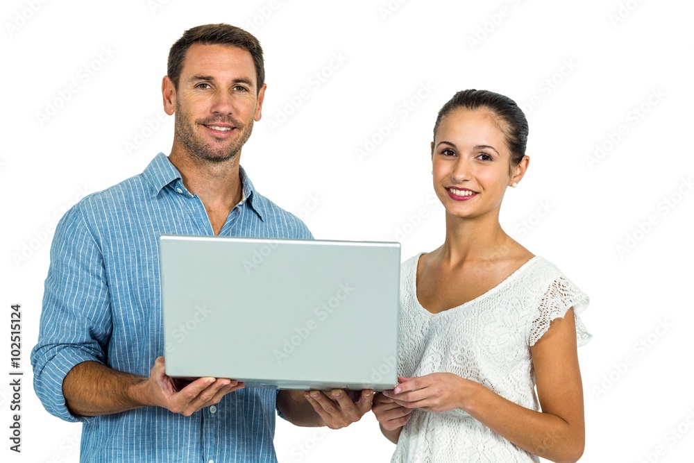 Young couple holding laptop and looking at camera Young couple holding laptop and looking at camera