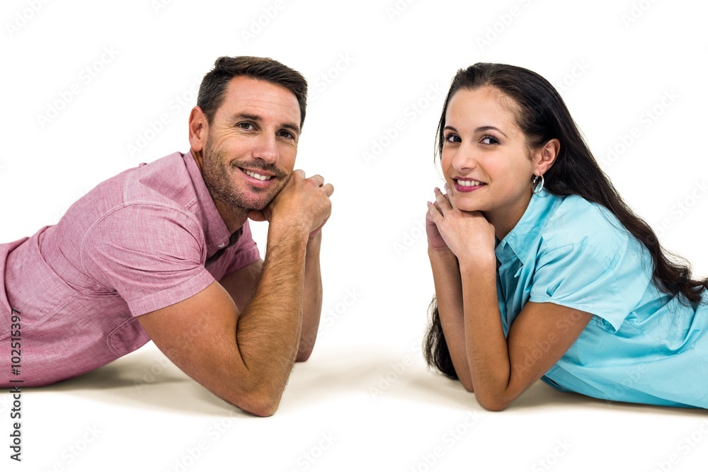 Smiling couple laying on the floor face to face looking at the c Smiling couple laying on the floor face to face looking at the c