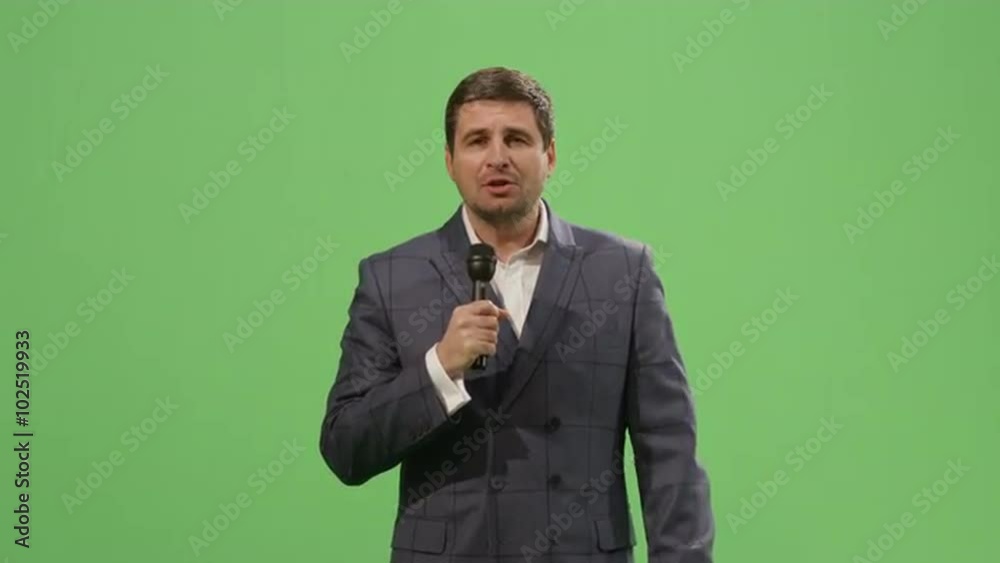 Media reporter with a microphone is talking on a mock-up green screen in the background. Shot on RED Cinema Camera. Media reporter with a microphone is talking on a mock-up green screen in the background. Shot on RED Cinema Camera.