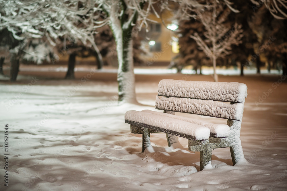 bench with snow after snowstorm or in snow calamity in europe, winter night  photograhy in city
