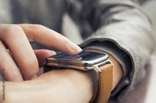 Closeup of woman's hands using a smartwatch