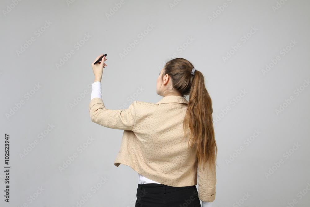 young woman with pen on grey background