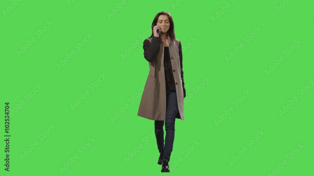 Casual young brunette girl in a dress is walking on a mock-up green screen in the background. Shot on RED Cinema Camera. Casual young brunette girl in a dress is walking on a mock-up green screen in the background. Shot on RED Cinema Camera.
