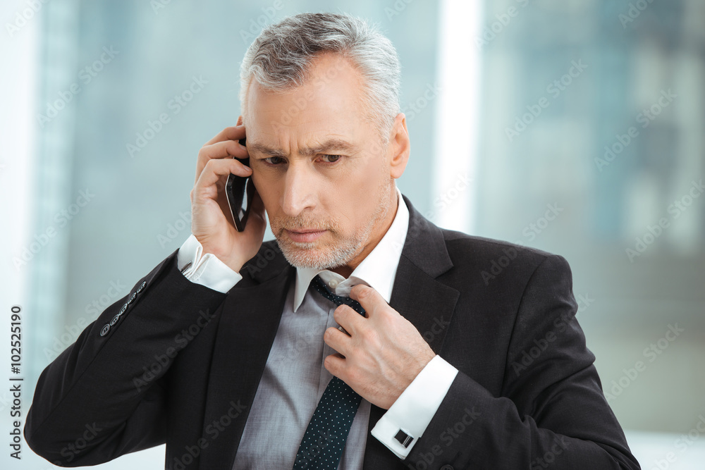 Aged businessman in office with big window