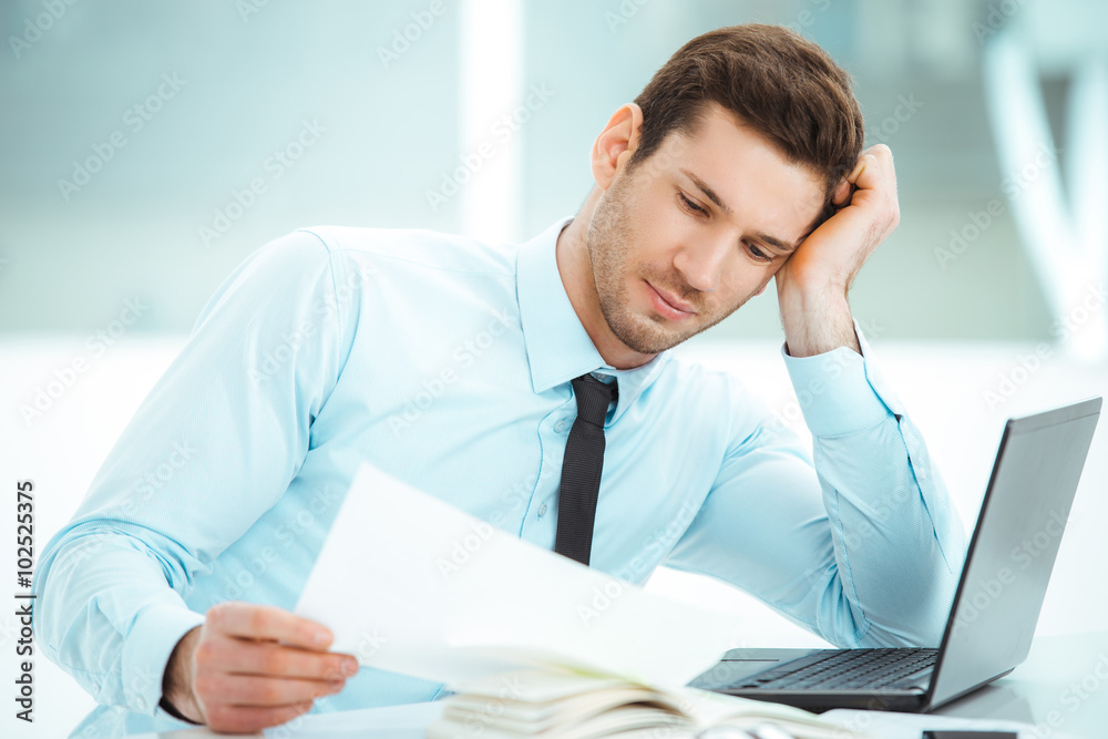 Young businessman in office with big window Young businessman in office with big window