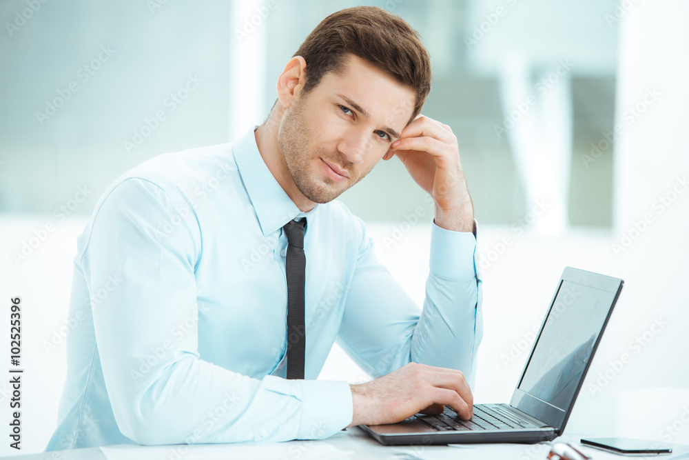 Young businessman in office with big window Young businessman in office with big window