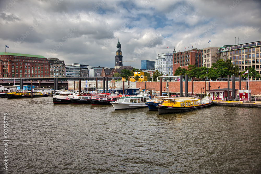 Downtown Hamburg on a cloudy day. Tourist boats passing on the waterways.