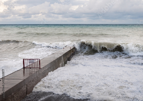 Storm waves roll on the breakwater.