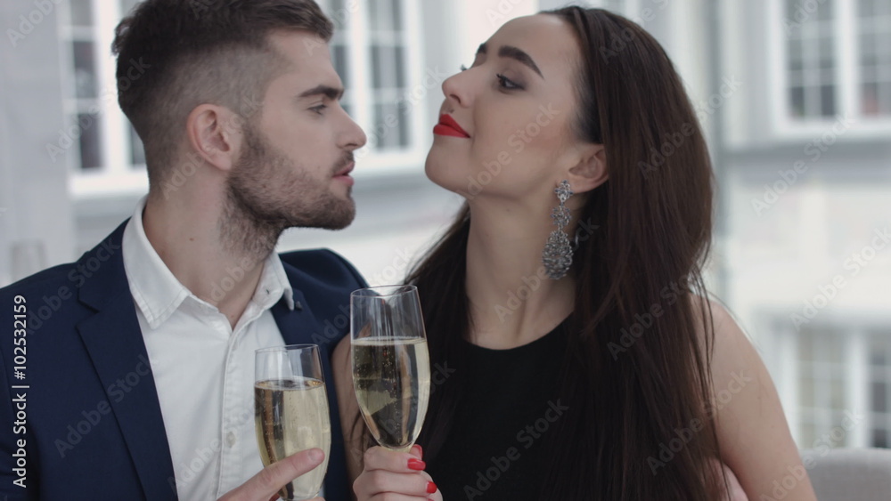 restaurant, couple and holiday concept - smiling couple with glass of champagne looking at each other at restaurant restaurant, couple and holiday concept - smiling couple with glass of champagne looking at each other at restaurant