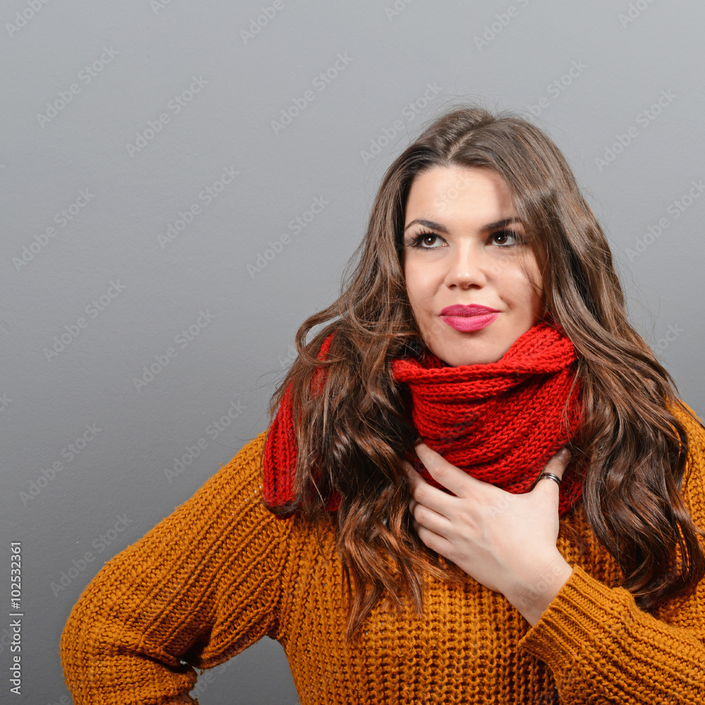 Portrait of young woman in winter clothes against gray backgroun Portrait of young woman in winter clothes against gray backgroun