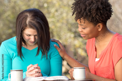 Woman praying for each other