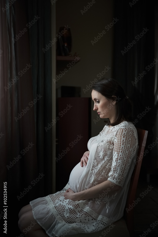 Fototapeta premium Pregnant woman sitting on a chair