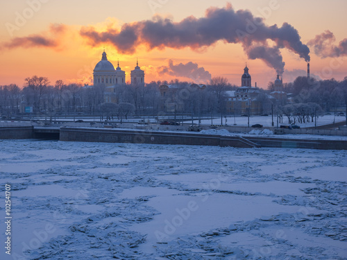 St. Petersburg in the winter. Alexander Nevsky Lavra on the banks of the frozen Neva River on a background of frosty sunset