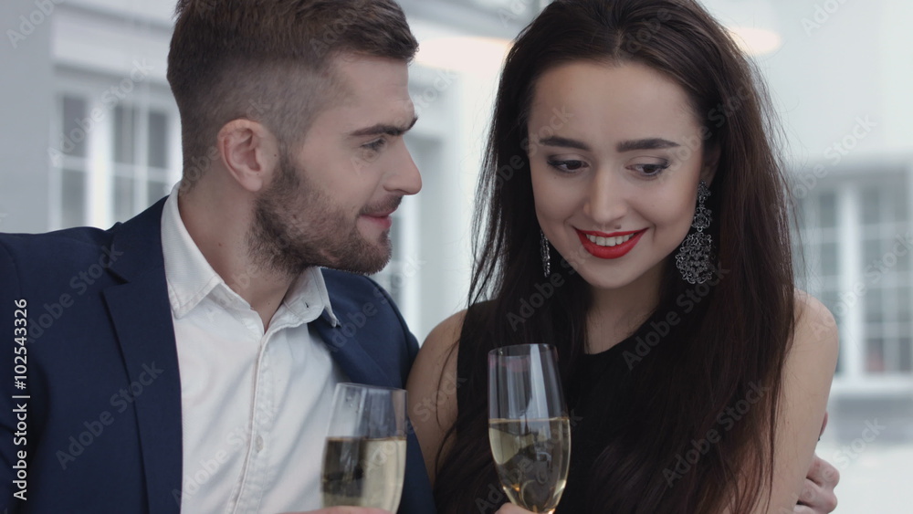 Young happy amorous couple with glasses of champagne on romantic date at restaurant Young happy amorous couple with glasses of champagne on romantic date at restaurant