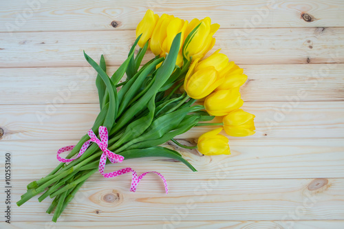 Yellow tulips on a wooden surface