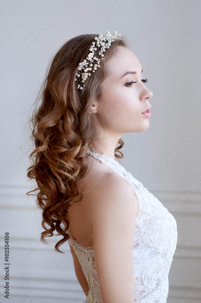 Bridal hairstyle and makeup. Young woman wearing headpiece.