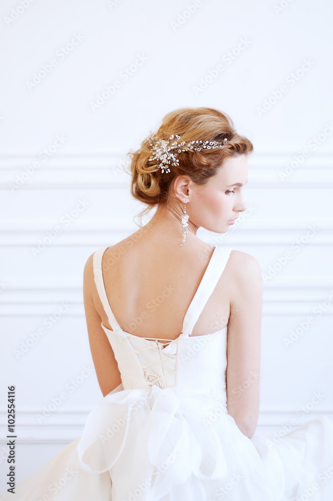 Bridal hairstyle and makeup. Young woman wearing headpiece. Bridal hairstyle and makeup. Young woman wearing headpiece.