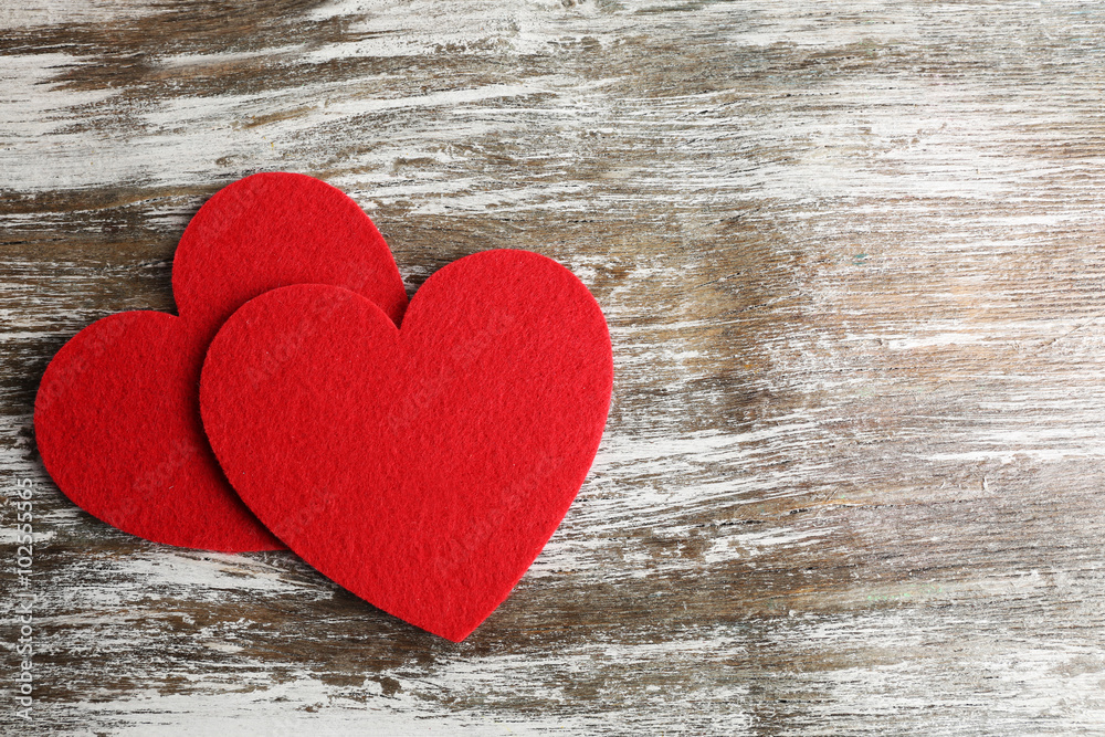 Red felt hearts on grey wooden background Red felt hearts on grey wooden background