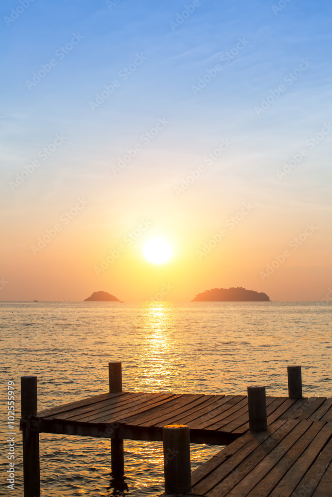 Wooden catwalk on the beach during sunset.