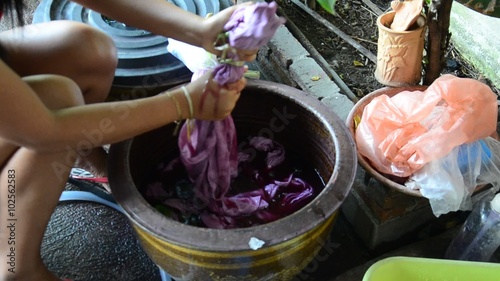 Thai women tie batik dyeing red and pink natural color made from Kerridae at Nonthaburi, Thailand. photo