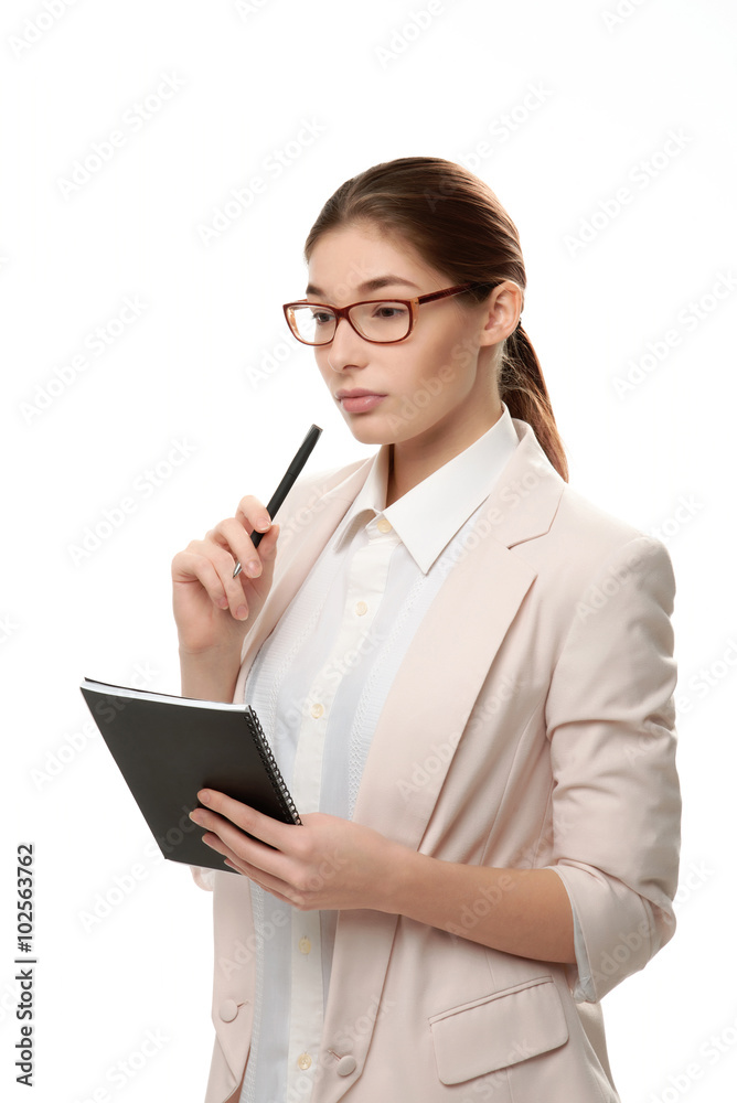 Young stylish woman standing holding a notepad and a pen. Young stylish woman standing holding a notepad and a pen.