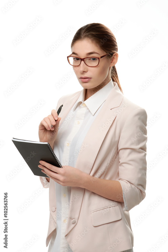 Young stylish woman standing holding a notepad and a pen. Young stylish woman standing holding a notepad and a pen.
