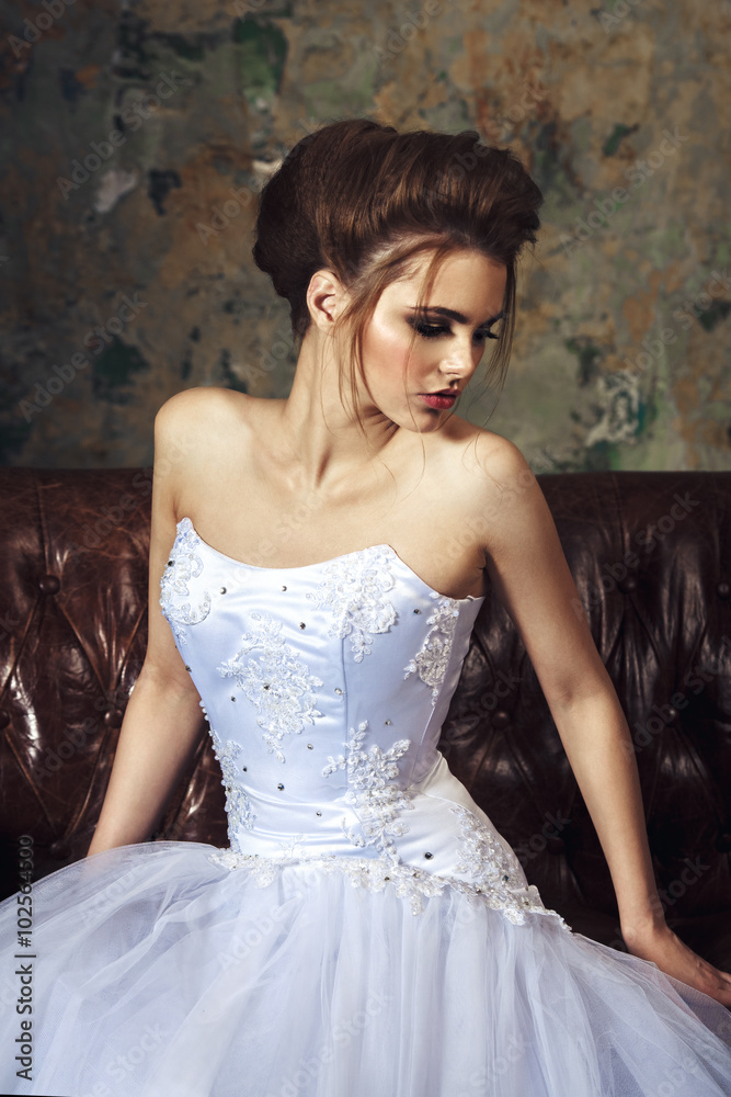 Young beautiful bride sensualy posing in white wedding dress